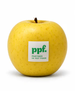 Mela gialla con etichetta edibile ppf. Partner in Pet Food su sfondo bianco