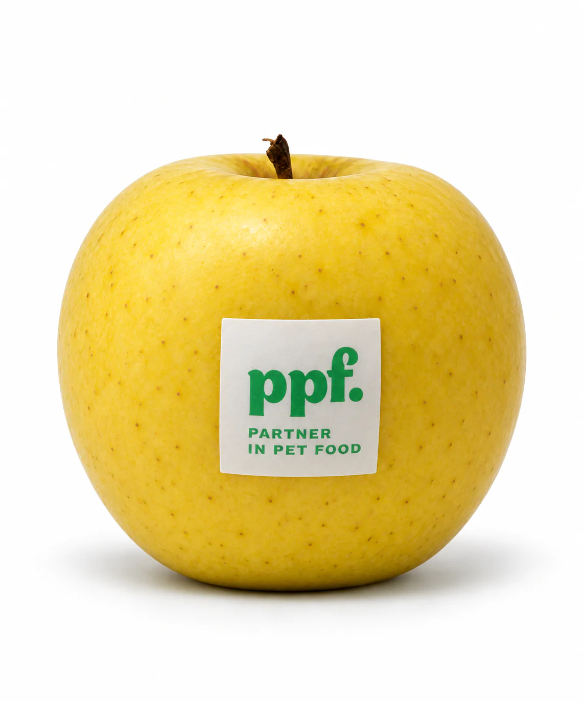 Mela gialla con etichetta edibile ppf. Partner in Pet Food su sfondo bianco